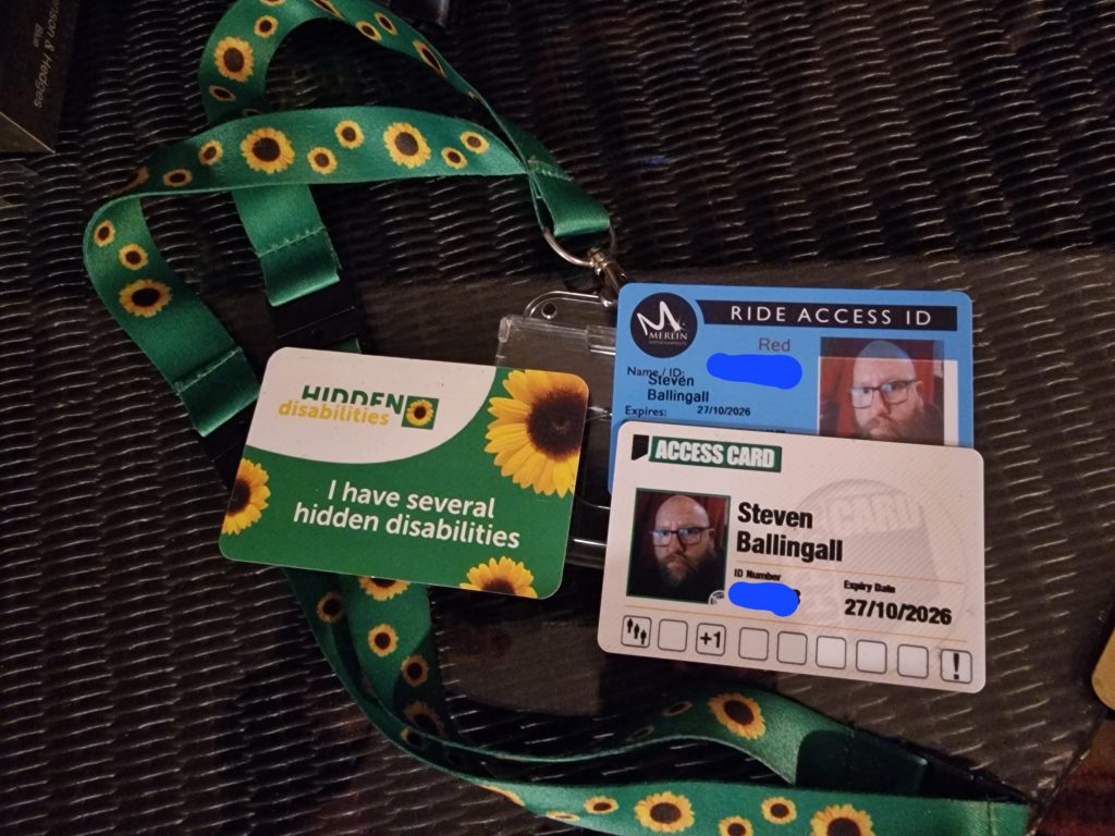 Hidden Disabilities, Merlin Ride Access and Nimbus Access cards sitting on top of a sunflower lanyard.